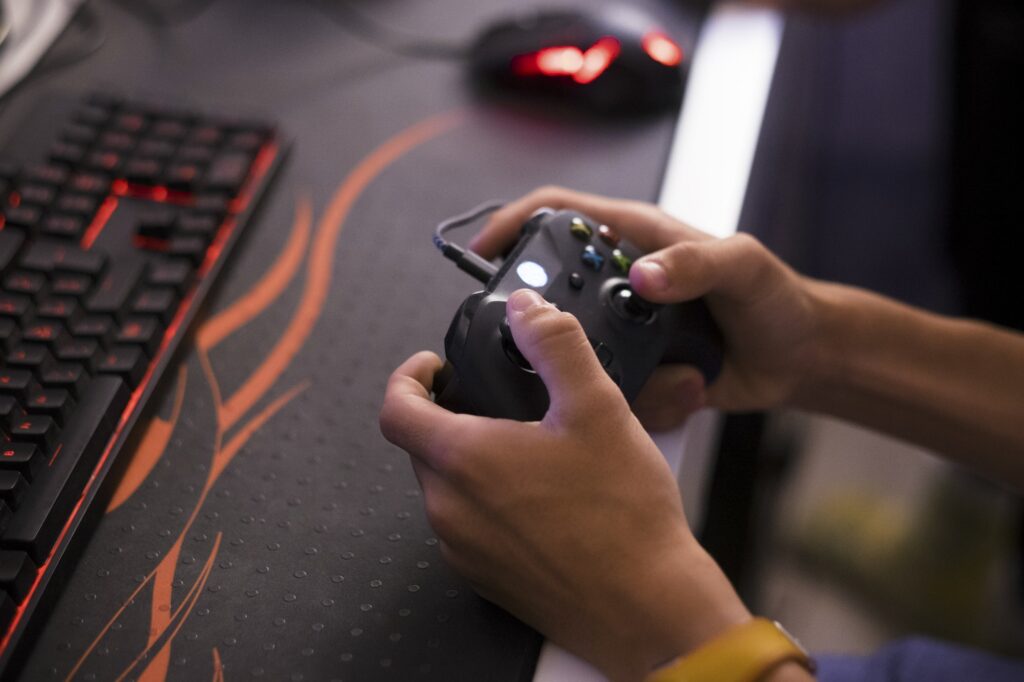 close up of hands playing videogames and holding a controller